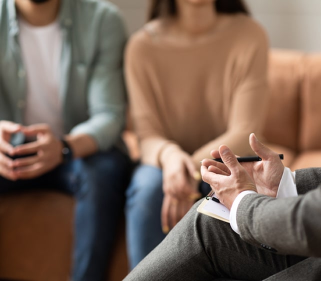 Therapist speaking with a couple during a counseling session, emphasizing communication and relationship support.