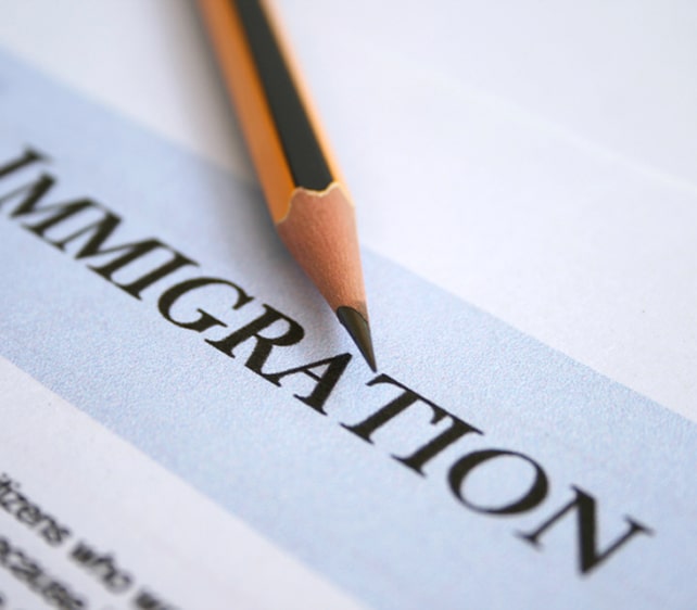 Pencil resting on a document titled “Immigration”, symbolizing evaluation and documentation services.